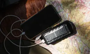 Telefon i powerbank na mapie, pokazujące, jak działa powerbank w podróży.