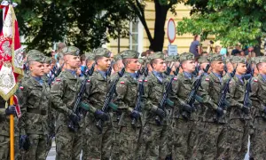 Żołnierze w mundurach polowych, z karabinami, maszerują w defiladzie. To widok z kategorii e wojsko, symbol dumy narodowej.
