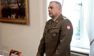 Generał w polskim mundurze, jeden z wielu na liście generałów w Polsce, stoi w sali.