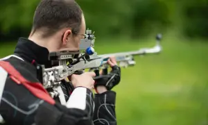 Strzelec celuje z wiatrówki sportowej. Zastanawiasz się, jaki zasięg ma wiatrówka? Ten model pozwala na precyzyjne strzelanie na znaczne odległości.