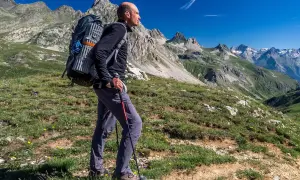 Mężczyzna z plecakiem wędruje przez malownicze tereny via alpina.