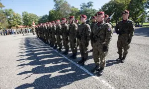 Żołnierze w mundurach i beretach stoją w szeregu. Dwie belki i gwiazdka na ich mundurach symbolizują stopień wojskowy.