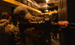 Żołnierze ćwiczą taktykę CQB (Close Quarters Battle) w ciasnych korytarzach, przygotowując się do walki na bliskim dystansie.