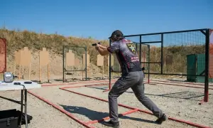 Strzelec w dynamicznej postawie na strzelnicy IPSC. To właśnie ipsc co to jest – sportowe strzelanie dynamiczne.
