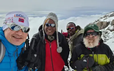Czterech mężczyzn w górskim krajobrazie. Jeden z nich, w czapce z flagą Norwegii, przypomina o Aleksandrze Doba, którego śmierć wstrząsnęła światem.