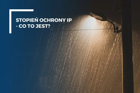 Lampa uliczna świeci w deszczu. Tekst: "Stopień ochrony IP - co to jest?". IP56 oznacza ochronę przed pyłem i silnymi strumieniami wody.