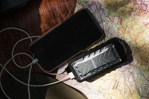 Telefon i powerbank na mapie, pokazujące, jak działa powerbank w podróży.