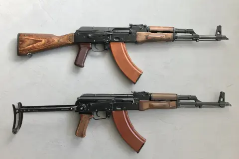 Dwa karabiny AK-47 z drewnianymi i brązowymi elementami. Standardowy magazynek mieści 30 naboi, ale istnieją też większe.