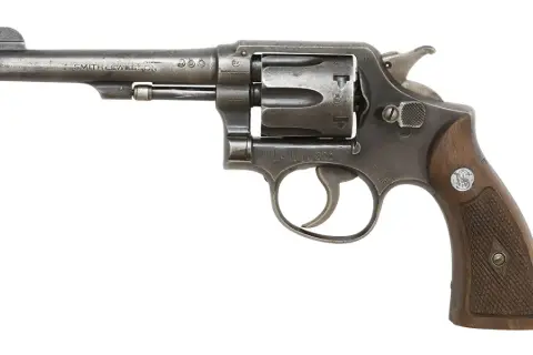 Rewolwer Smith & Wesson, klasyczna budowa rewolweru z drewnianą rękojeścią, gotowy do akcji.