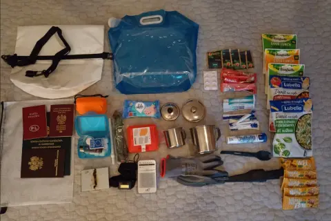 Zestaw survivalowy: plecak jako bagaż rejestrowany, paszporty, woda, jedzenie, apteczka, kubki, rękawice, radio.