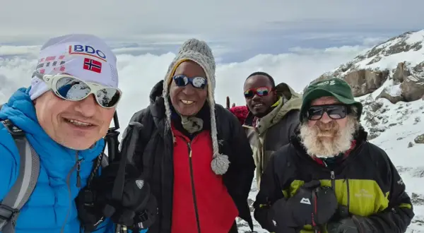 Czterech mężczyzn w górskim krajobrazie. Jeden z nich, w czapce z flagą Norwegii, przypomina o Aleksandrze Doba, którego śmierć wstrząsnęła światem.