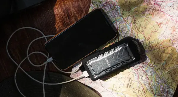 Telefon i powerbank na mapie, pokazujące, jak działa powerbank w podróży.