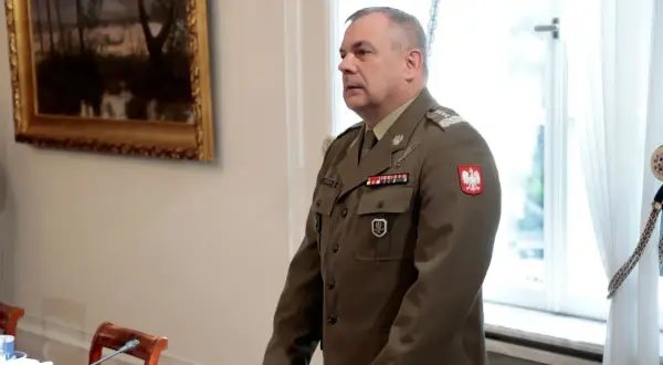 Generał w polskim mundurze, jeden z wielu na liście generałów w Polsce, stoi w sali.