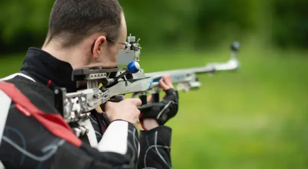 Strzelec celuje z wiatrówki sportowej. Zastanawiasz się, jaki zasięg ma wiatrówka? Ten model pozwala na precyzyjne strzelanie na znaczne odległości.