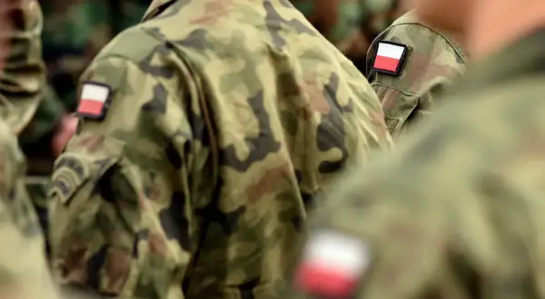 Żołnierze w mundurach moro z polskimi flagami na ramionach, symbolizujący chodzenie w mundurze poza jednostką.