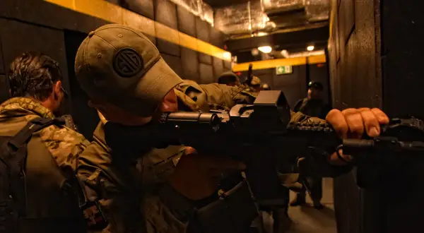 Żołnierze ćwiczą taktykę CQB (Close Quarters Battle) w ciasnych korytarzach, przygotowując się do walki na bliskim dystansie.