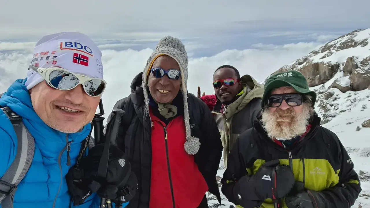 Czterech mężczyzn w górskim krajobrazie. Jeden z nich, w czapce z flagą Norwegii, przypomina o Aleksandrze Doba, którego śmierć wstrząsnęła światem.