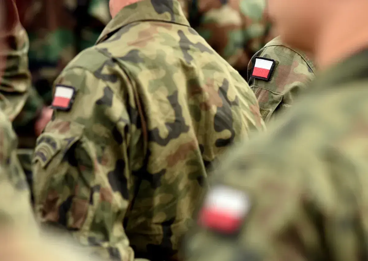 Żołnierze w mundurach moro z polskimi flagami na ramionach, symbolizujący chodzenie w mundurze poza jednostką.