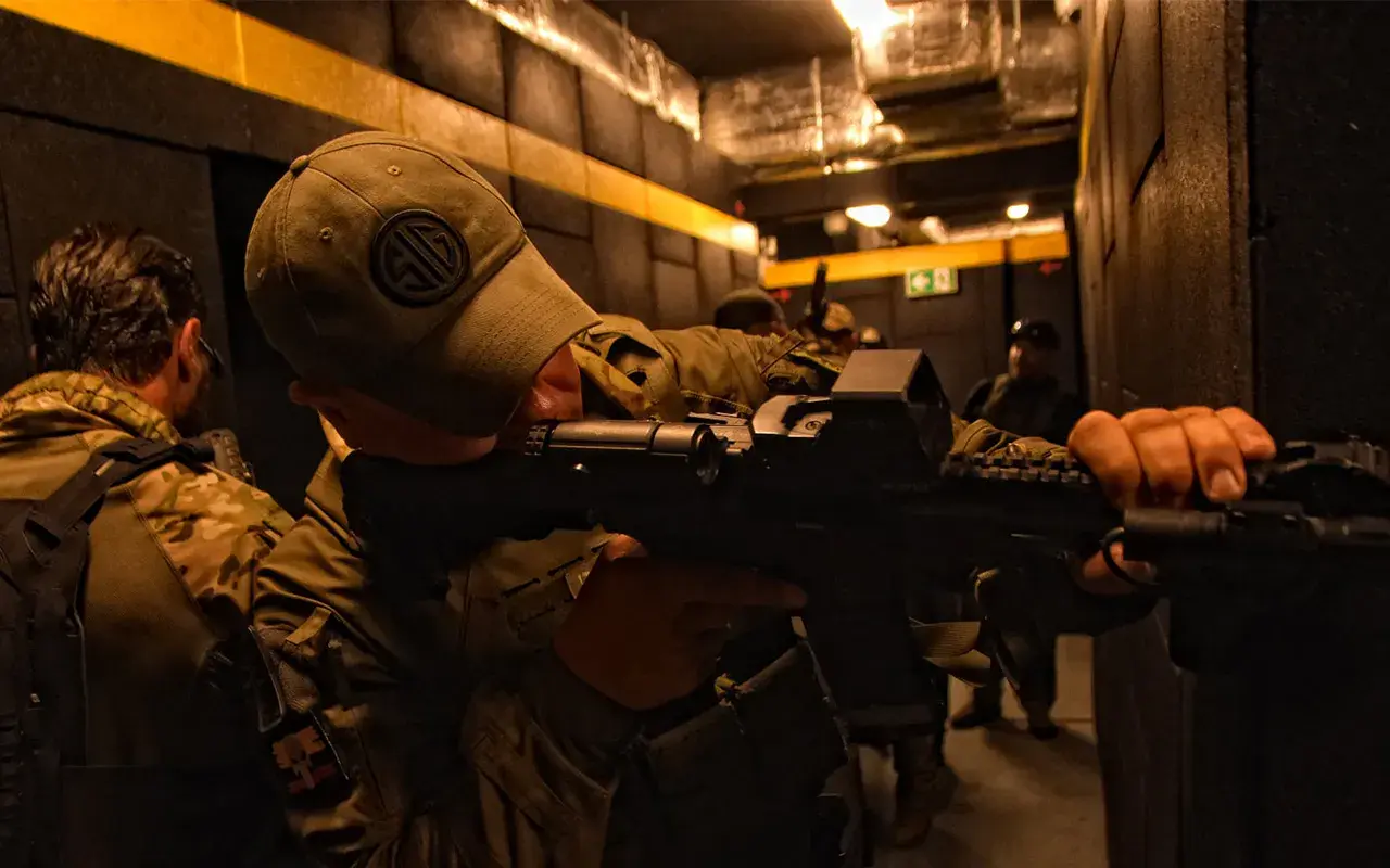 Żołnierze ćwiczą taktykę CQB (Close Quarters Battle) w ciasnych korytarzach, przygotowując się do walki na bliskim dystansie.