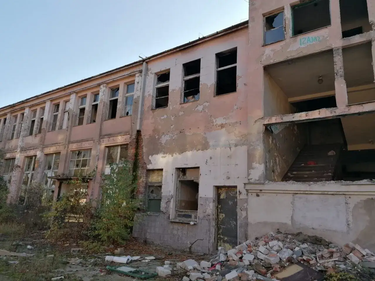 Opuszczony budynek z wybitymi oknami i gruzem na zewnątrz. Czy urbex jest legalny? To pytanie zadają sobie eksploratorzy ruin.