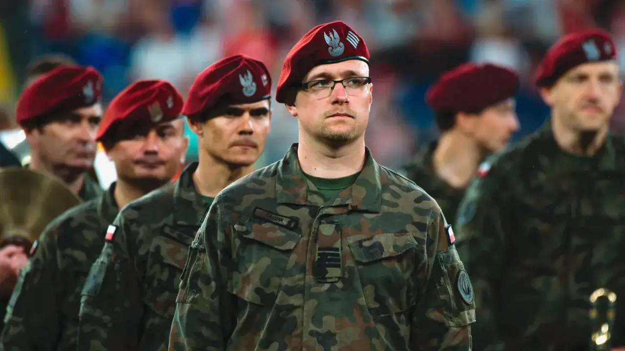 Żołnierze w mundurach i charakterystycznych czerwonych beretach z orłem. Kto nosi czerwone berety? Ci żołnierze.