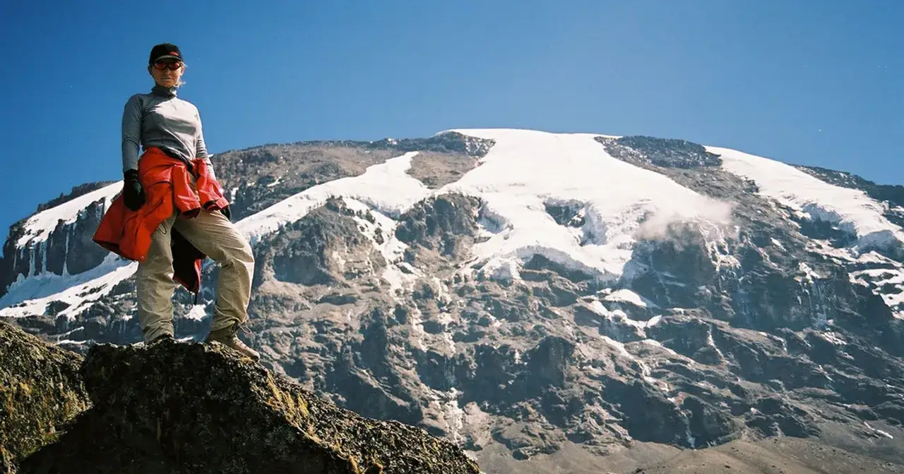 Martyna Wojciechowska na tle ośnieżonego szczytu, być może Mount Everest. Wyprawa w góry.