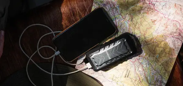 Telefon i powerbank na mapie, pokazujące, jak działa powerbank w podróży.