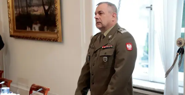 Generał w polskim mundurze, jeden z wielu na liście generałów w Polsce, stoi w sali.