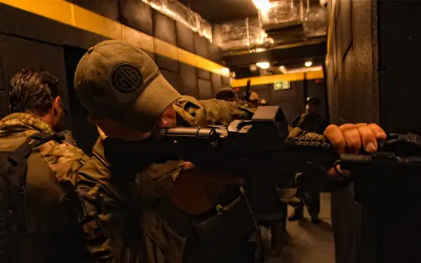 Żołnierze ćwiczą taktykę CQB (Close Quarters Battle) w ciasnych korytarzach, przygotowując się do walki na bliskim dystansie.